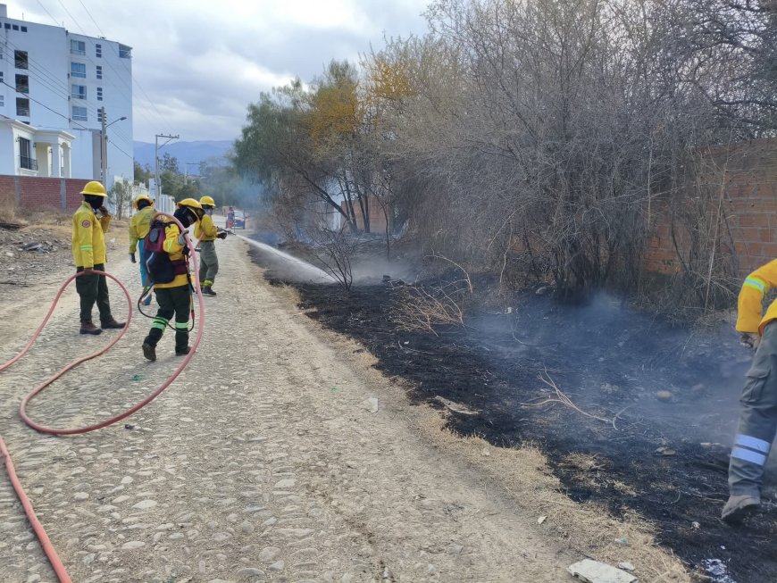 Bomberos voluntarios controlan incendio de pastizales en el barrio Miraflores.
